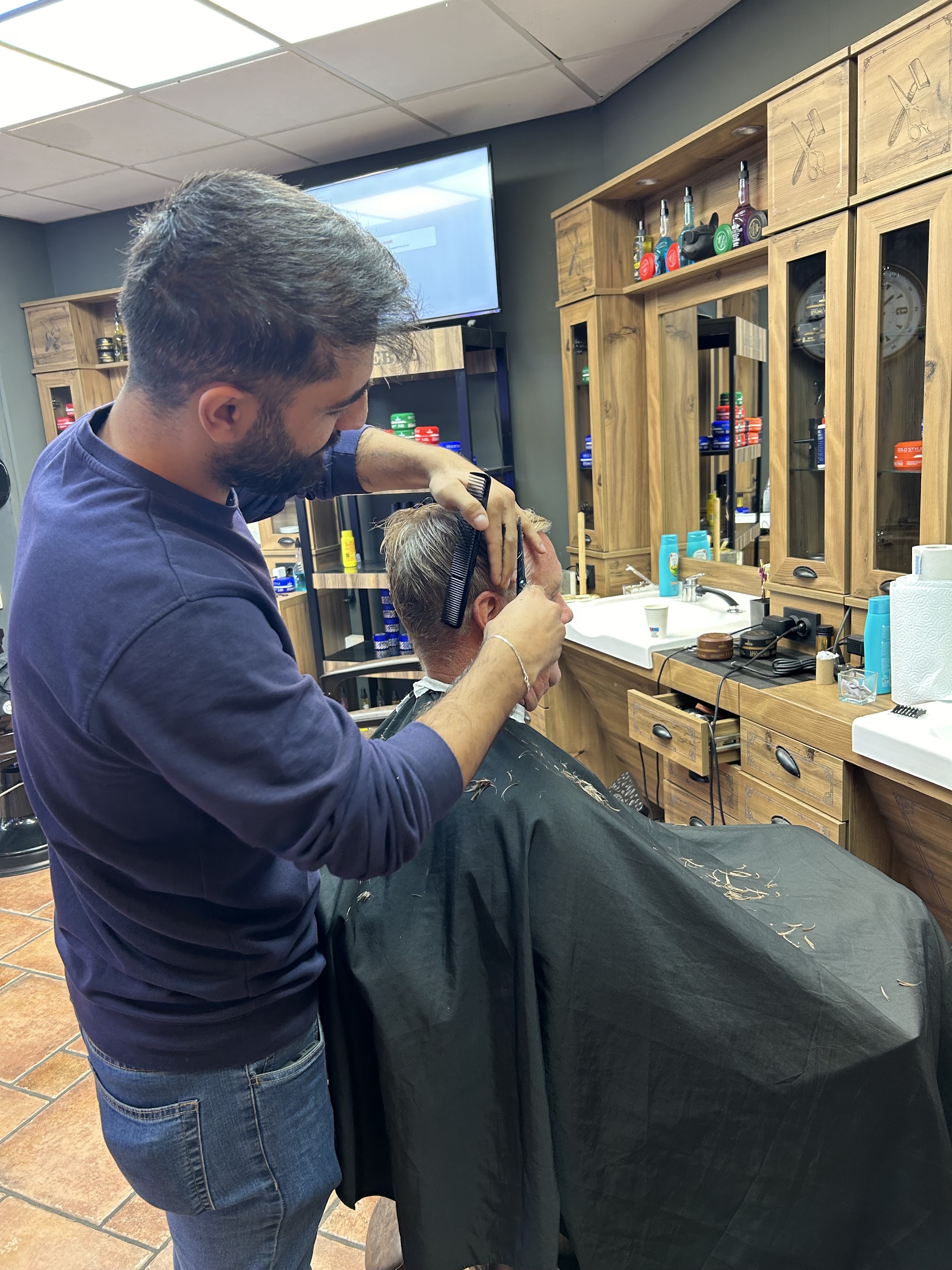Barbier knipt met schaar en kam
